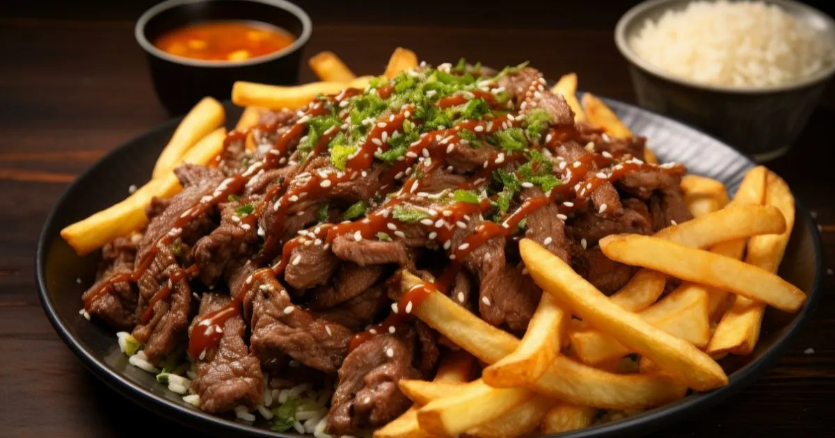 Plate of thin sliced beef topped with sesame seeds and sauce, served with crispy fries, rice, and dipping sauce.