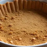 Gluten-free graham cracker crust in a white pie dish, ready for filling.