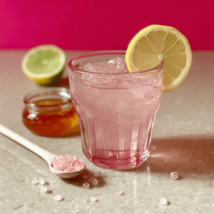 Pink Salt Recipe for Weight Loss: Simple Morning Ritual 3 Pink salt recipe drink with ice, lemon slice garnish, honey and pink Himalayan salt